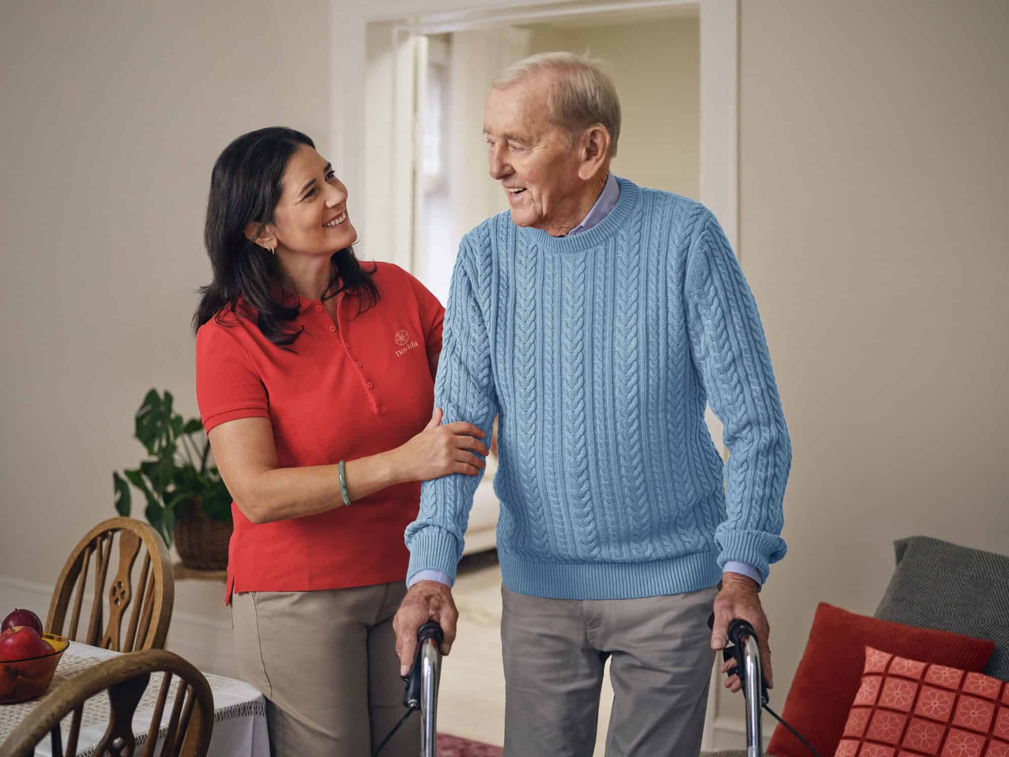 Female caregiver helps male client to stand