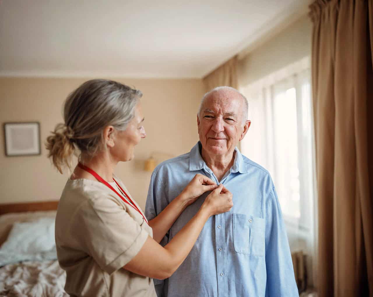 Carer helps person living with arthritis to button shirt as part of arthritis care service